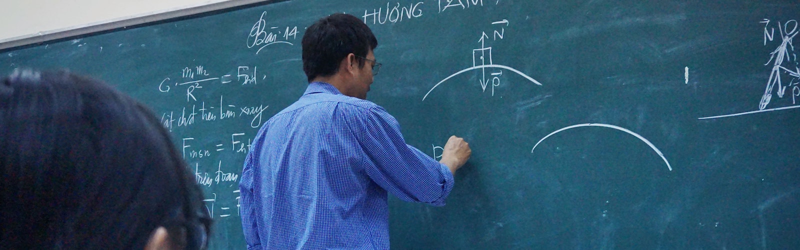close up of an instructor writing on a chalkboard